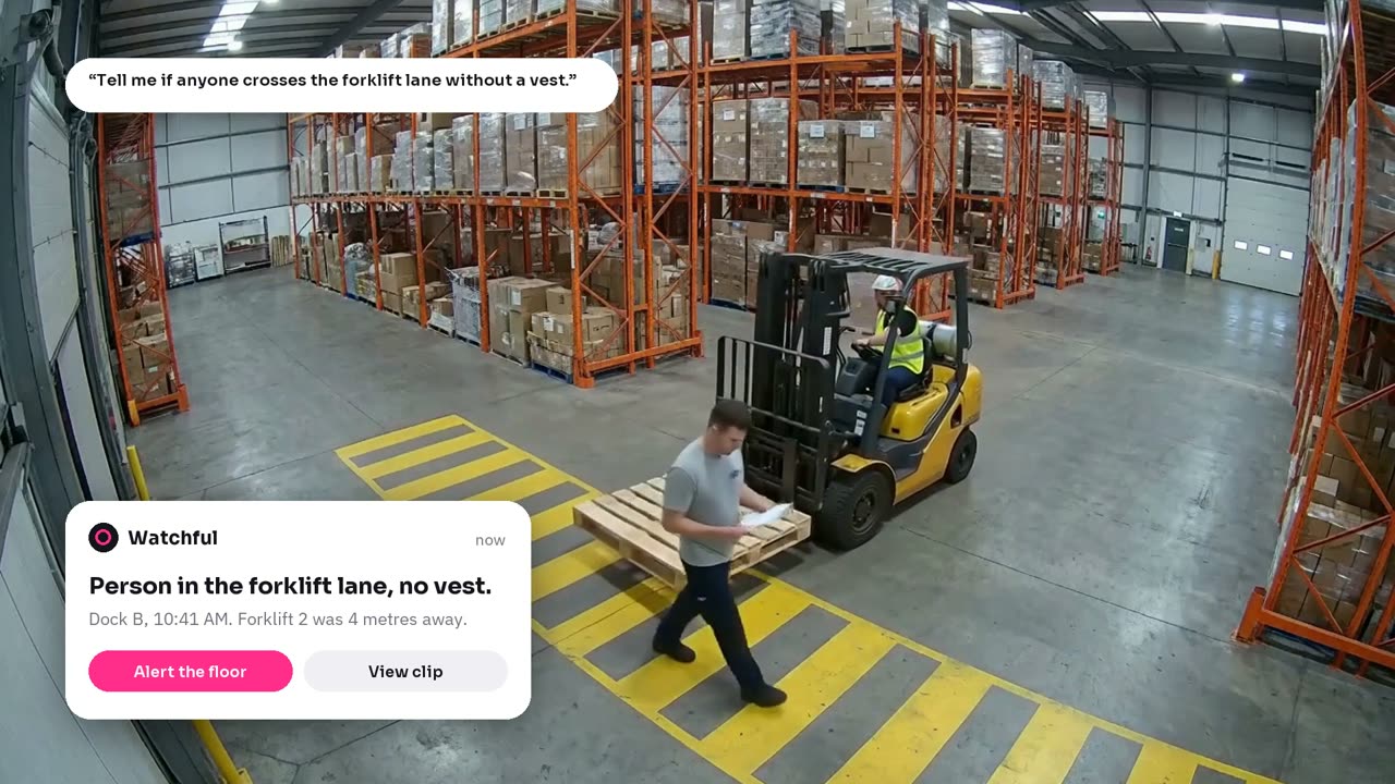 A warehouse camera: a person walks in the forklift lane without a vest, and Watchful's alert names it.